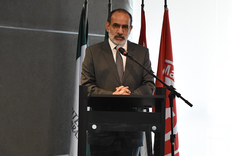 Ciro fala no microfone atrás do pulpito, localizado no palco em que aconteceu o evento, próximo a algumas bandeiras. 