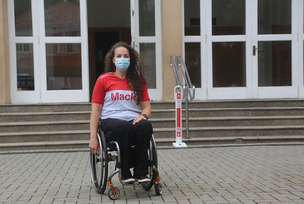 mulher sentada em uma cadeira de rodas em frente ao auditório do Mackenzie 