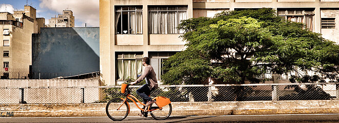 homem andando de bicicleta sobre o Elevado João Goulart