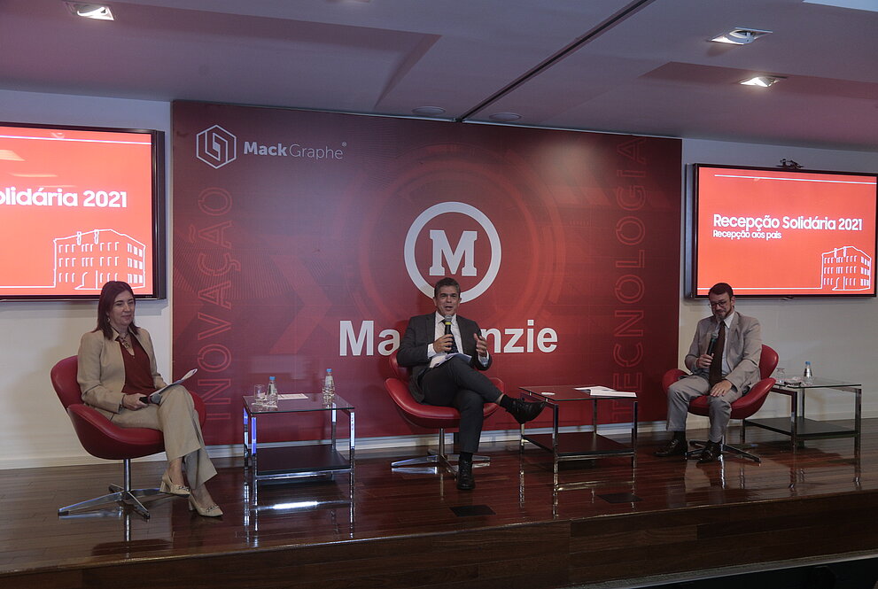 três pessoas sentadas respeitando o distanciamento social 