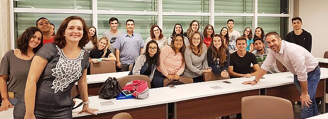 Participantes da palestra posando para foto estando alguns sentados e outros de pé