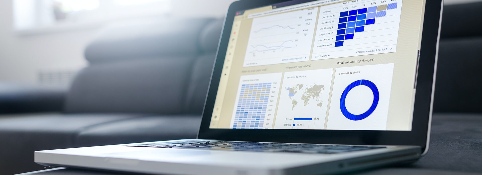 laptop sobre uma mesa cinza, na tela, há gráficos e dados variados